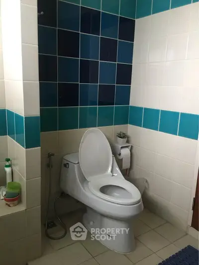 Modern bathroom with stylish blue tile accents and sleek toilet design.
