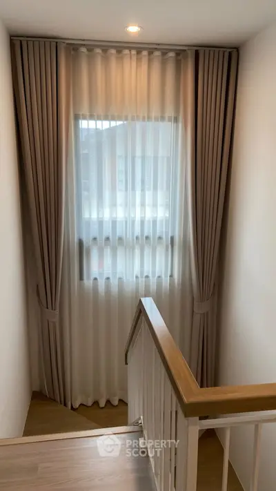 Elegant staircase with modern curtains and natural light