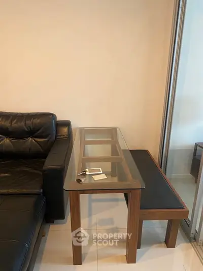 Modern living room with glass table and leather sofa, perfect for stylish urban living.