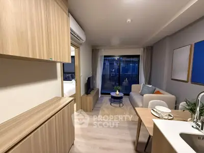 Modern living room with cozy sofa, stylish decor, and open kitchen layout in a contemporary apartment.