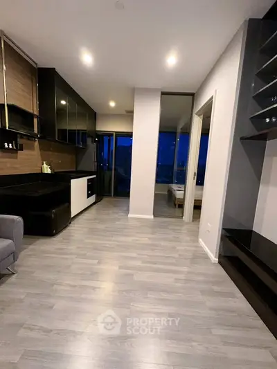 Modern open-plan living room with sleek kitchen and balcony view