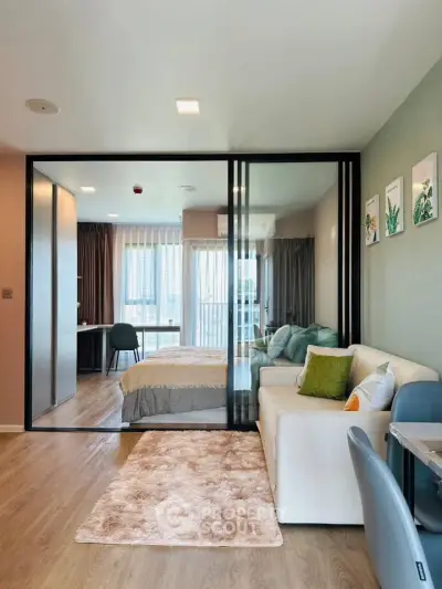 Modern studio apartment with glass partition, cozy living area, and stylish decor.