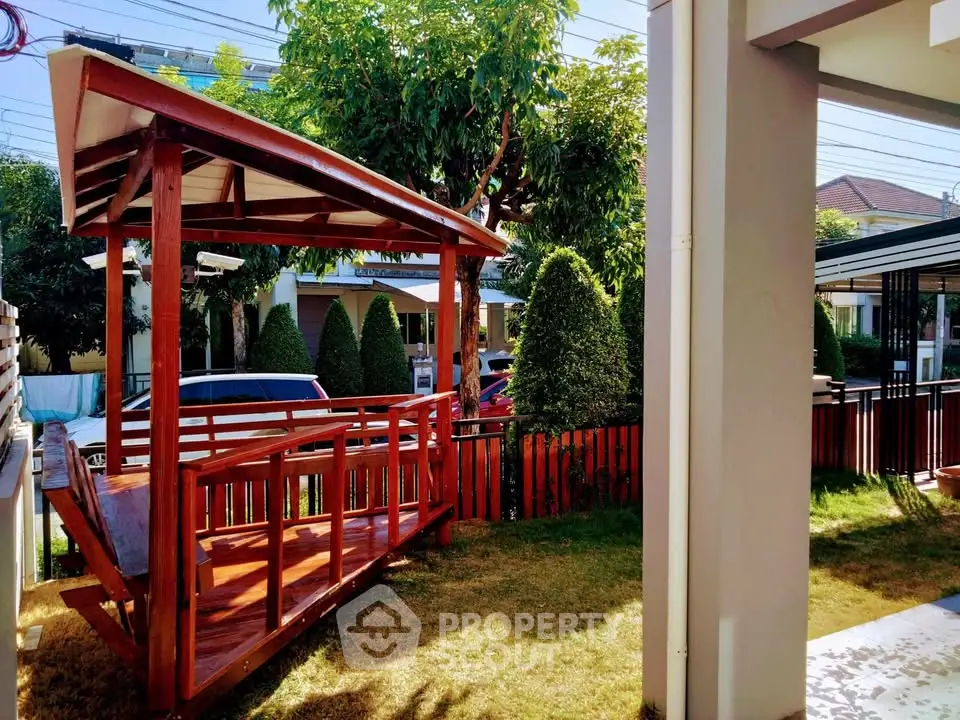 Charming garden with wooden swing and lush greenery in a serene residential area.