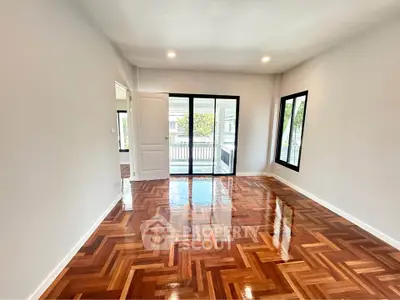 Spacious living room with polished wooden floors and large windows