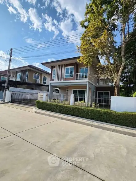 Modern two-story house with spacious driveway and lush greenery in a serene neighborhood.