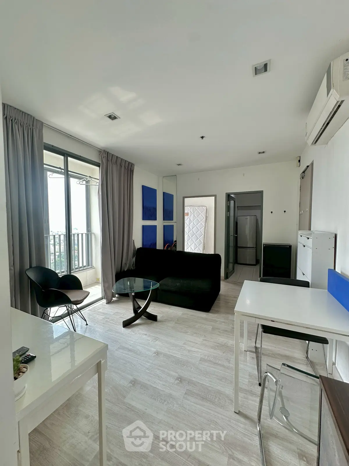 Modern living room with balcony view, stylish furniture, and natural light.