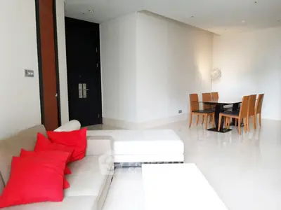 Modern living room with stylish dining area and red accent pillows