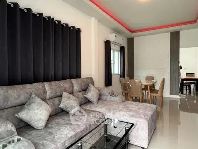 Modern living room with stylish gray sofa and elegant dining area, featuring chic decor and ambient lighting.