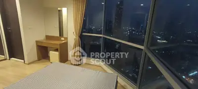 Luxurious bedroom with stunning city view through floor-to-ceiling windows, featuring elegant decor and ambient lighting.