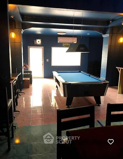 Chic recreational room with pool table and modern lighting, perfect for entertainment and relaxation.
