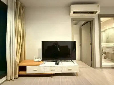 Modern living room with TV, air conditioning, and stylish furniture in a cozy apartment setting.