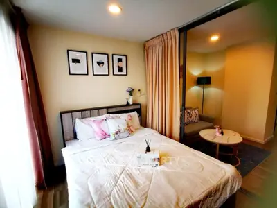 Cozy bedroom with stylish decor and adjacent sitting area in modern apartment