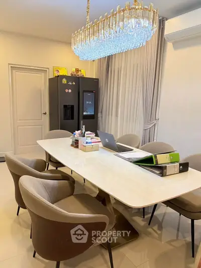Elegant dining room with modern chandelier and sleek furniture, perfect for stylish gatherings.