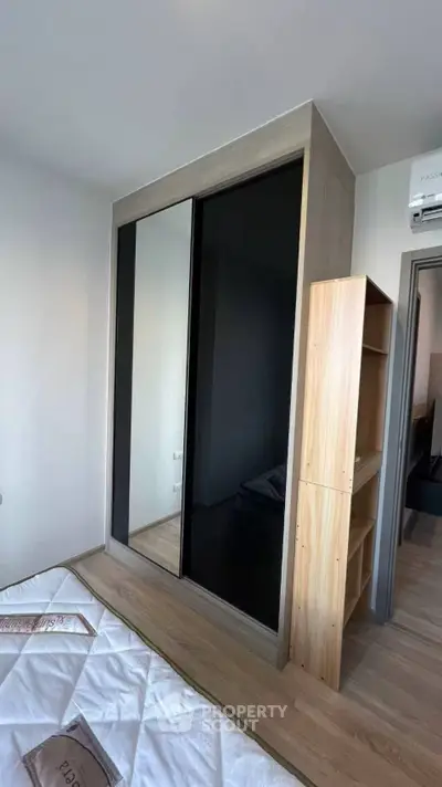 Modern bedroom with sleek wardrobe and wooden flooring
