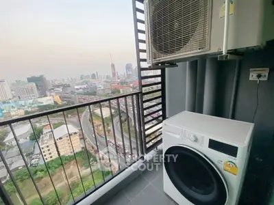 High-rise balcony with city view and laundry appliances, perfect urban living.