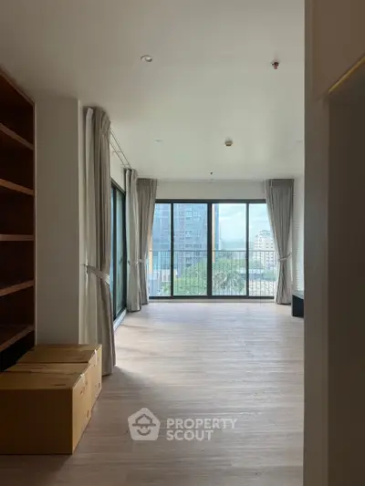 Spacious living room with large windows and balcony view in modern apartment