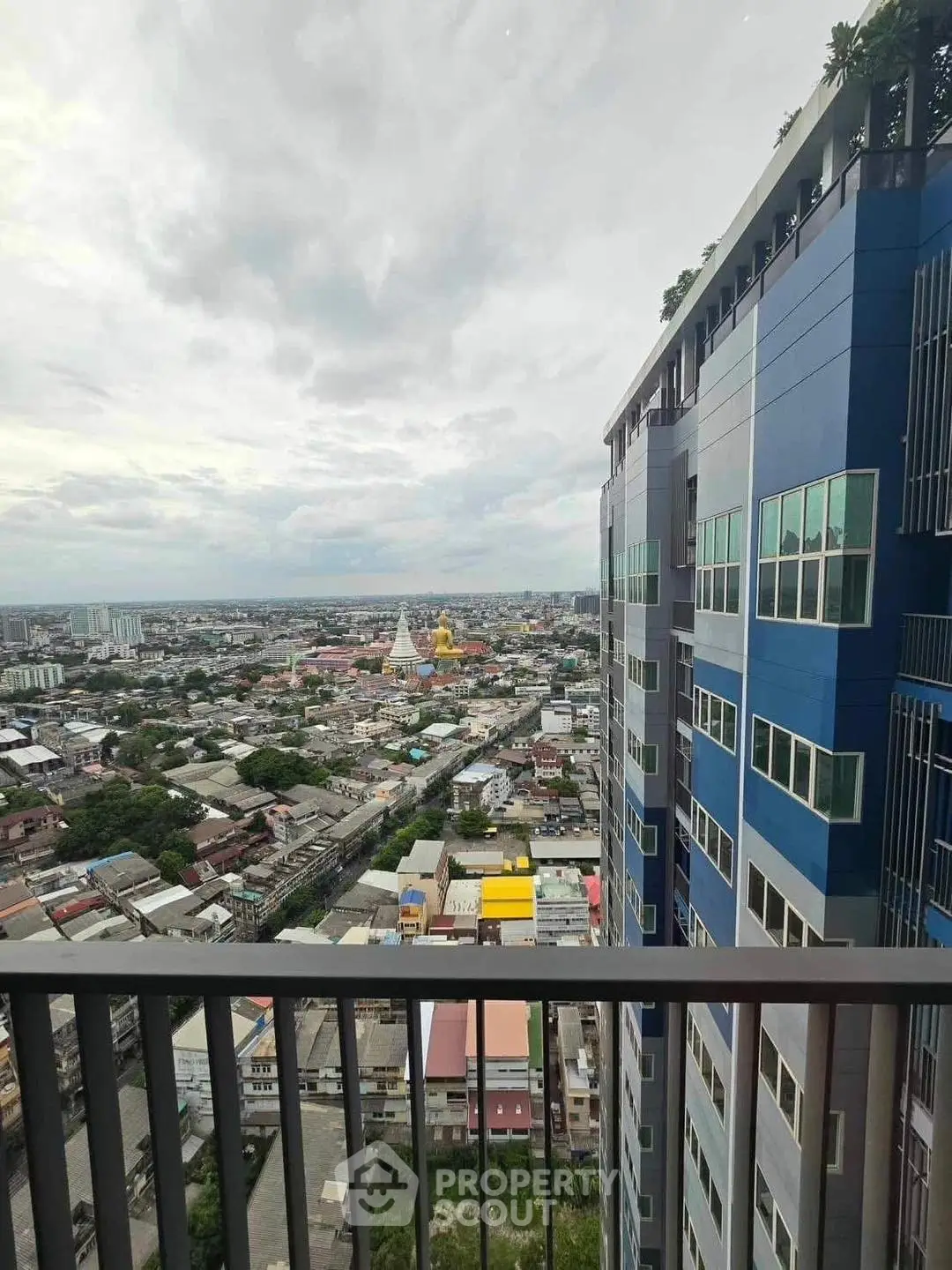 Stunning cityscape view from high-rise balcony with modern building facade.