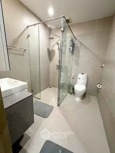 Modern bathroom with glass shower enclosure and sleek fixtures