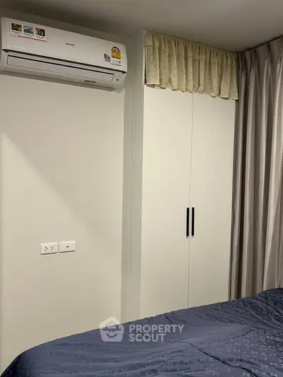Cozy bedroom with air conditioning and built-in wardrobe, perfect for comfortable living.