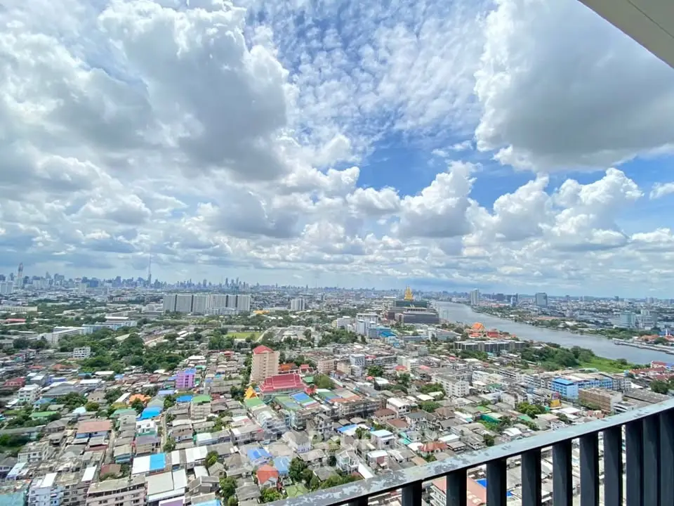 Stunning panoramic cityscape view from high-rise balcony with vibrant skyline and river.
