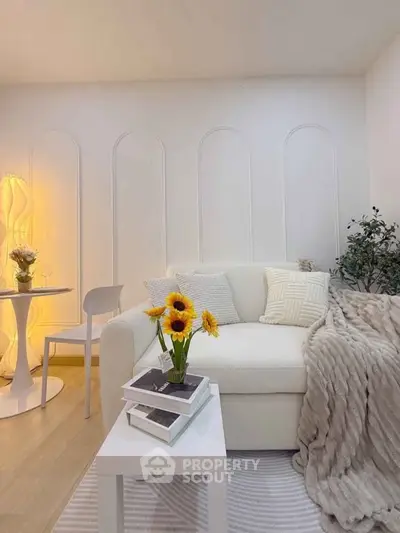 Cozy living room with elegant white sofa, stylish decor, and warm lighting, perfect for relaxation.