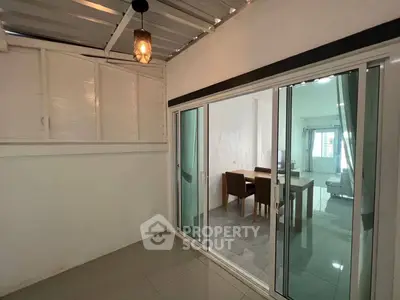 Modern interior with sliding glass doors leading to a cozy dining area and living room.