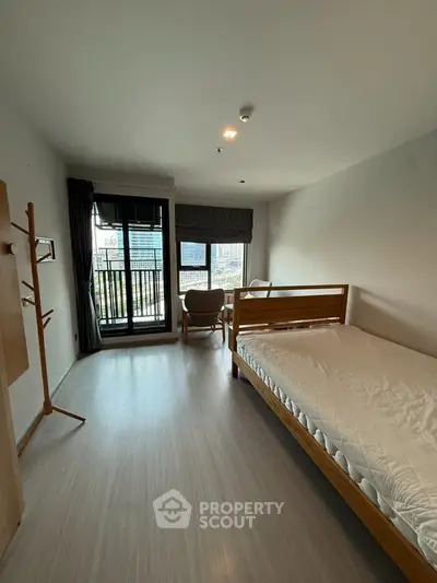 Spacious bedroom with balcony and city view in modern apartment