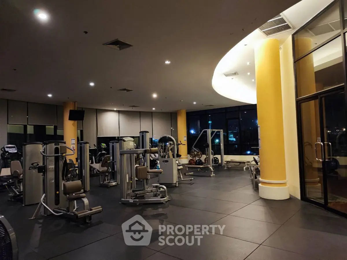 Spacious modern gym with state-of-the-art equipment and large windows.