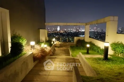 Stunning rooftop garden with panoramic city skyline views at night.