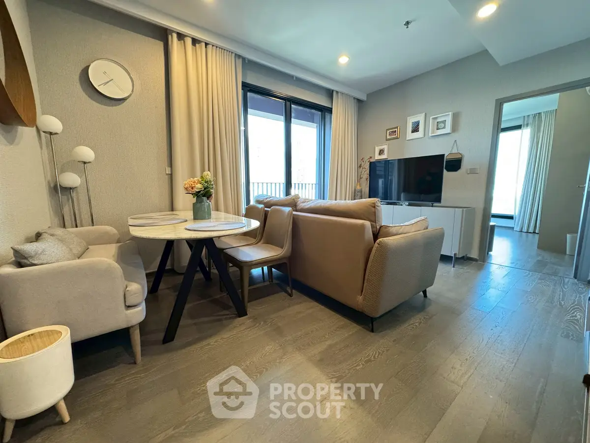 Modern living room with cozy seating and stylish decor, featuring a TV and dining area.