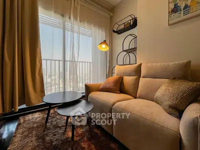 Cozy living room with plush sofa and modern decor, featuring a sunlit balcony view.