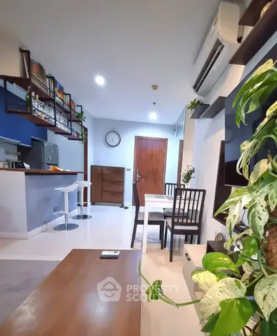 Modern living room with open kitchen, stylish decor, and cozy dining area in a contemporary apartment.
