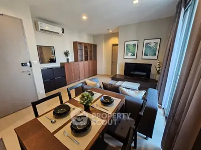 Modern living room with dining area, stylish furniture, and natural light