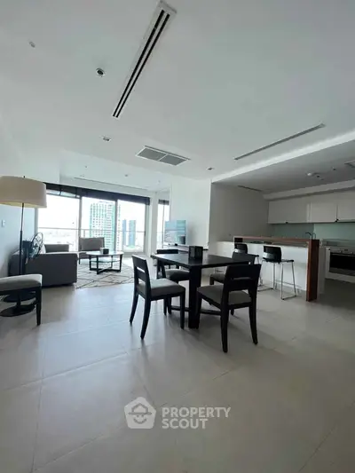 Spacious modern living room with open kitchen and city view, perfect for urban living.