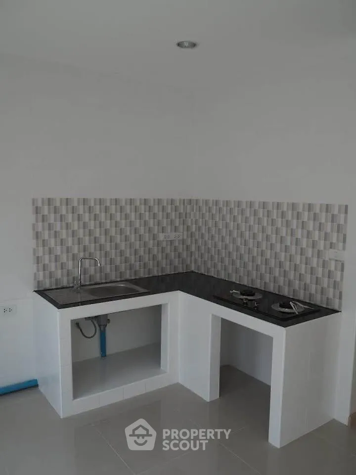 Modern minimalist kitchen with sleek black countertop and gas stove
