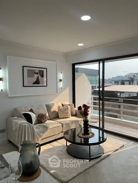 Modern living room with cozy sofa and balcony view, perfect for urban living.