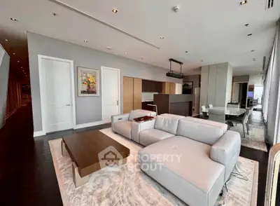 Luxurious modern living room with sleek furniture and open kitchen layout in high-rise apartment.