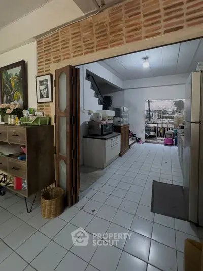 Charming kitchen with open layout and rustic brick accents, featuring modern appliances and ample storage space.