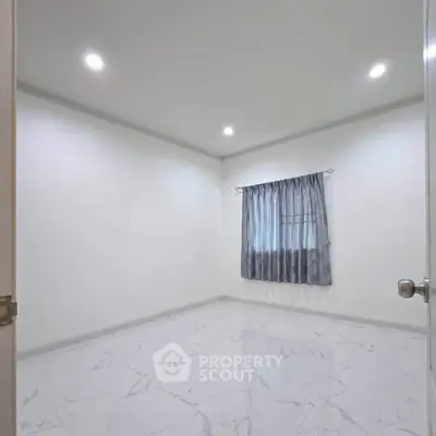 Spacious empty room with marble flooring and elegant curtains, perfect for customization.