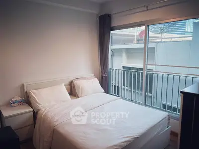 Cozy bedroom with large window and balcony view in modern apartment