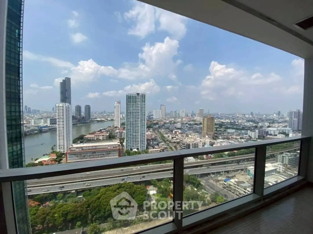Stunning cityscape view from high-rise balcony overlooking river and skyline.