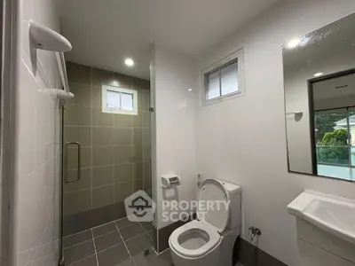 Modern bathroom with glass shower and sleek fixtures in a contemporary home.