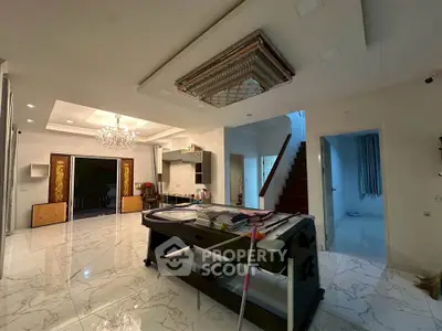 Spacious modern living area with elegant chandelier and marble flooring