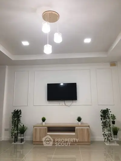 Modern living room with sleek TV setup and elegant lighting, perfect for stylish urban living.