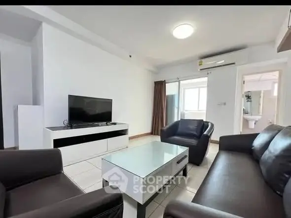 Modern living room with sleek furniture and flat-screen TV, ideal for relaxation.