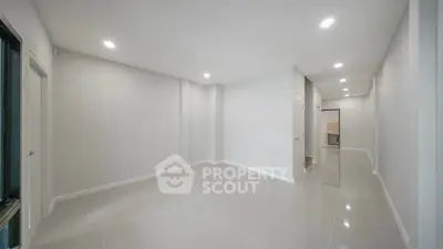 Spacious empty room with glossy tiled floors and recessed lighting, ideal for customization.