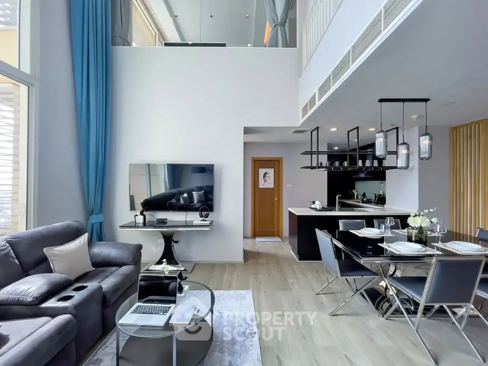 Modern duplex living room with high ceilings and stylish kitchen