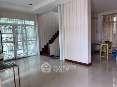 Spacious interior with elegant staircase and tiled flooring, perfect for modern living.