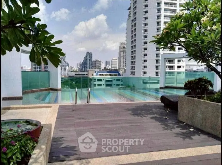 Stunning rooftop pool with city skyline views in modern high-rise building.