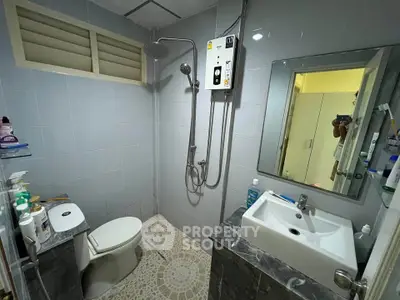 Modern bathroom with shower, toilet, and sink in a compact layout.